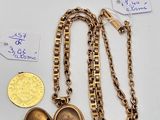 two gold lockes and a gold coin on a white surface