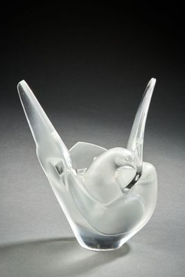 glass sculpture of a white bird on a black background