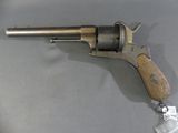 an old revolver with a wooden handle on a table
