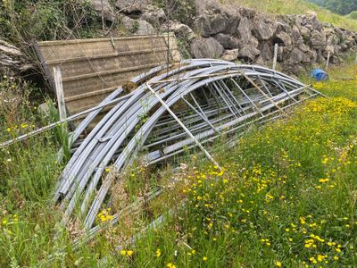 un tas de tuyaux métalliques dans un champ de fleurs