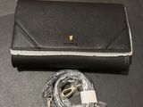 un sac à main noir muni d'une chaîne dorée et d'un étui transparent