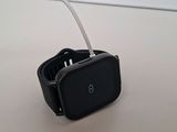 a close up of a smart watch on a table with a white cord