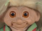 a troll doll with blonde hair and a green shirt