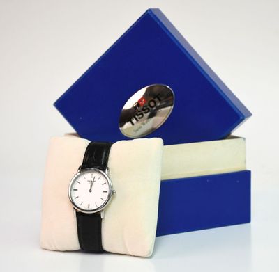 une boîte bleue sur laquelle est représentée une montre et qui contient une cuillère