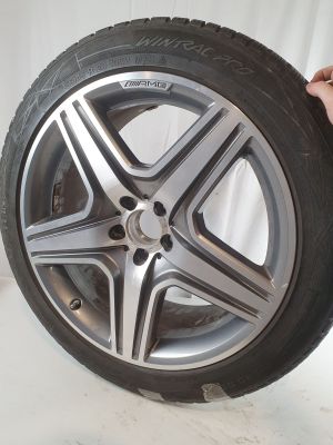 someone is holding a tire that has been placed on a white background