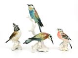 trois figurines d'oiseaux posées sur une surface blanche