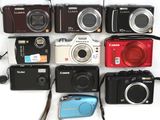 de nombreux modèles d'appareils photo numériques posés sur une surface blanche