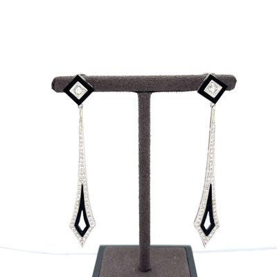 pair of black and white diamond earrings on a display stand