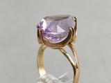 a close up of a gold ring with a purple stone on it