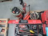 une perceuse rouge et d'autres outils dans une boîte