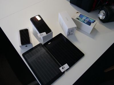 Plusieurs téléphones portables sont posés sur une table, à côté d'une boîte
