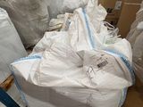 many bags of white bags on a pallet in a warehouse