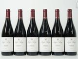 six bouteilles de vin rouge sont alignées sur une table