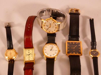 plusieurs types de montres sont alignés sur une surface blanche