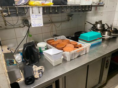 stainless steel counter top in a commercial kitchen with pots and pans on it