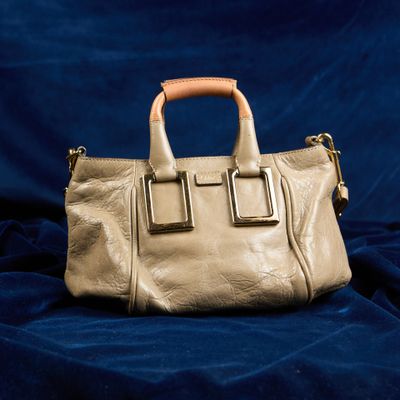 sac à main en cuir beige sur fond de velours bleu