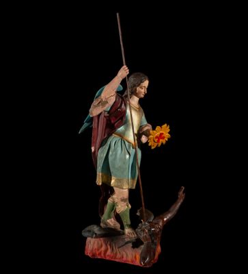 la statue d'un homme tenant une épée et une fleur à la main