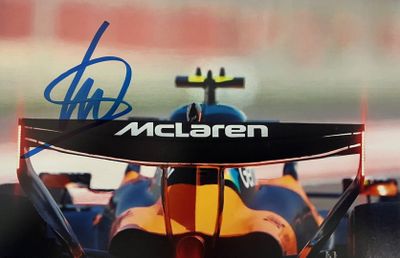 une image montrant un gros plan d'une voiture de course avec une signature sur le capot
