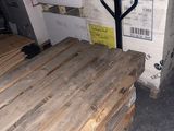 plusieurs palettes de bois sont empilées sur des palettes dans un entrepôt