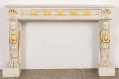 an image of a white marble fireplace with gold decorations
