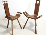 two wooden chairs sitting next to each other on a white floor