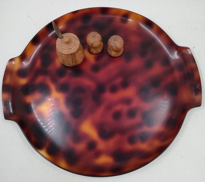 un plateau en forme de carapace de tortue sur lequel sont posés deux salières et poivrières