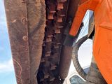 a close up of a construction vehicle with a truck in the background