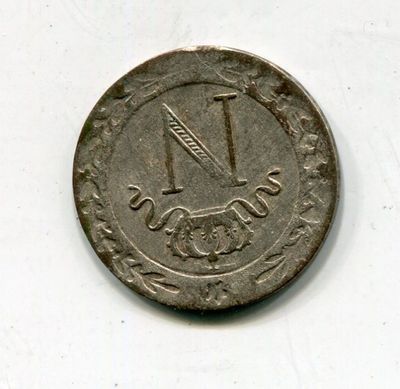une vieille pièce de monnaie sur laquelle figure le chiffre « 1 » sur un fond blanc