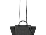 a black handbag with a long strap on a white background