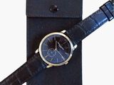 étui à montre en cuir noir contenant une montre et un bracelet noir
