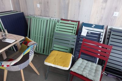 une pièce où se trouvent de nombreuses chaises de différentes couleurs et une table