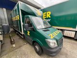 un camion vert garé devant un immeuble