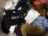 a box full of clothes and a hat on the floor