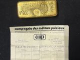 a gold bar and a piece of paper on a table