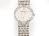un gros plan d'une montre sur une surface blanche avec un fond blanc