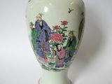 un vase blanc orné d'une peinture représentant des personnes