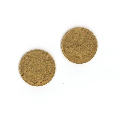 deux pièces d'or sur une surface blanche avec un fond blanc