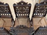 three wooden chairs with wicker seats sitting next to each other