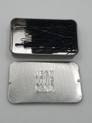 une boîte métallique contenant des broches, posée sur une table