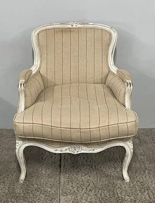 beige and white striped upholstered chair on carpeted floor