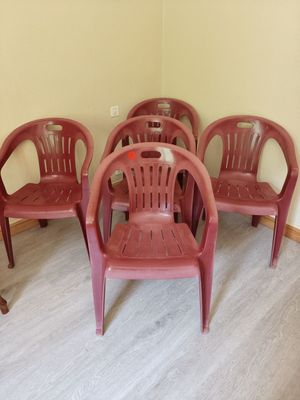several red plastic chairs are lined up in a row in the corner of a room
