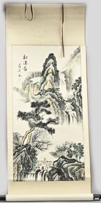 un rouleau chinois représentant un paysage de montagne, accroché au mur
