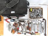 un sac d'outils posé sur une table à côté d'une paire de ciseaux