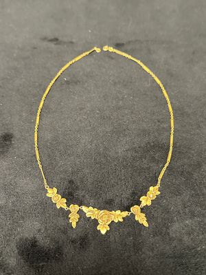 gros plan d'un collier en or sur une surface noire