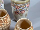 three vases with different designs on them sitting on a table