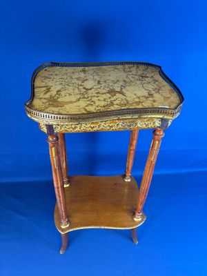 une petite table en bois avec un plateau en marbre sur fond bleu