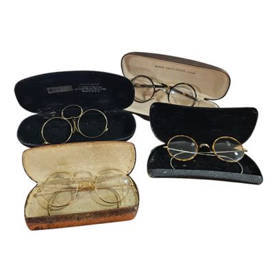 three pairs of glasses are in a case on a white surface