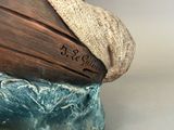 a sculpture of a boat with a hat on top of it