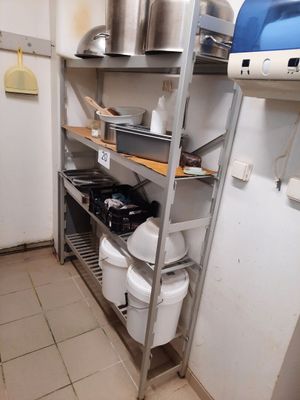 des étagères sur lesquelles sont posées des casseroles et des poêles dans une petite cuisine