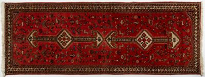 un tapis rouge orné d'un motif en losanges sur fond blanc